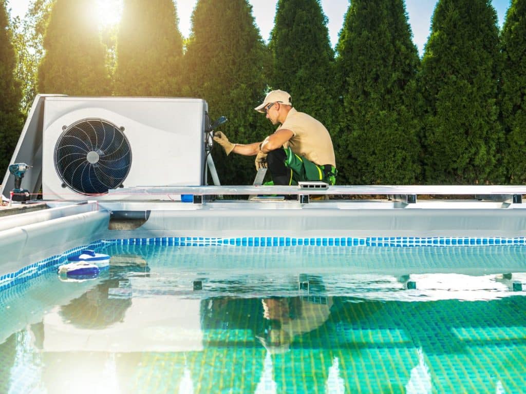 Installation de pompe à chaleur par un technicien piscine sur piscine enterrée