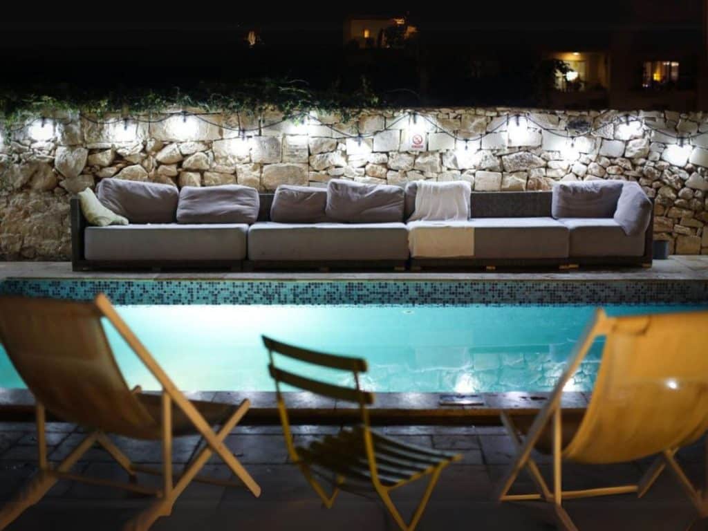 Décoration et banquette autour d'une piscine de nuit