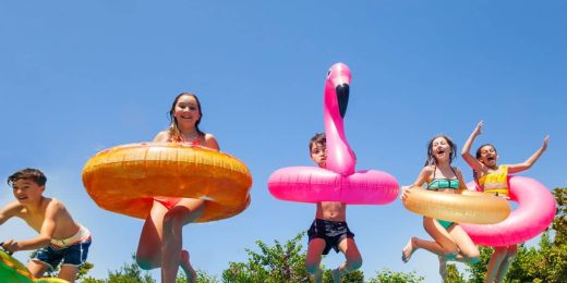 Enfants sautant dans une piscine avec des bouées géantes