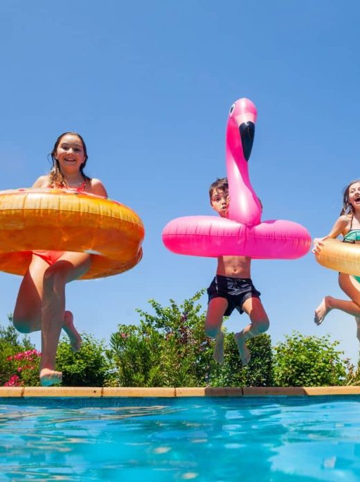 Enfants sautant dans une piscine avec des bouées géantes